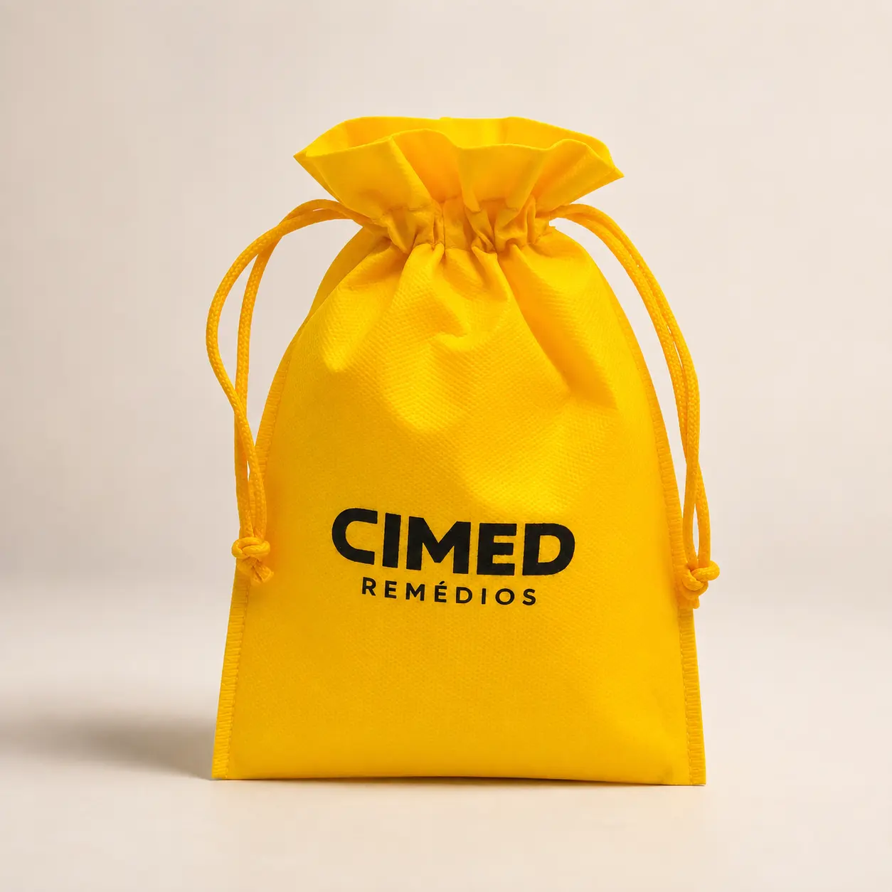 Saco de TNT amarelo com cordão personalizado Cimed